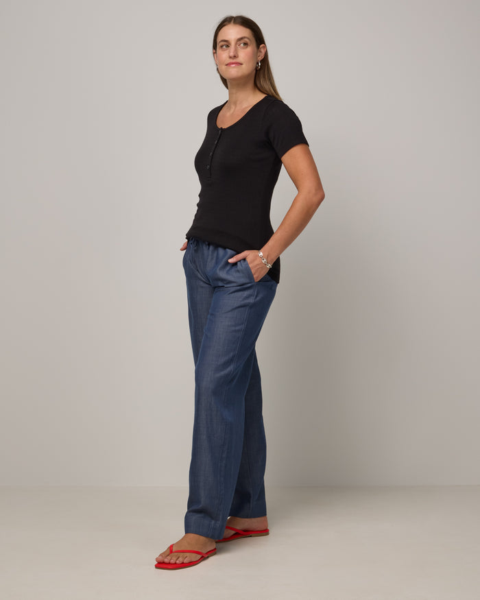 Model wearing Marie Pointelle Henley in Black. Marie Pointelle Henley is a short sleeve, scoop neck, fitted top available in sizes XS-3X.