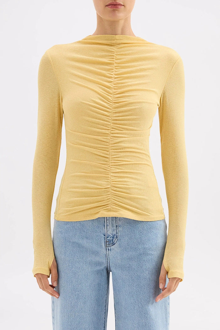 Yellow ruched long-sleeve top worn by a person on a white background
col_pattern