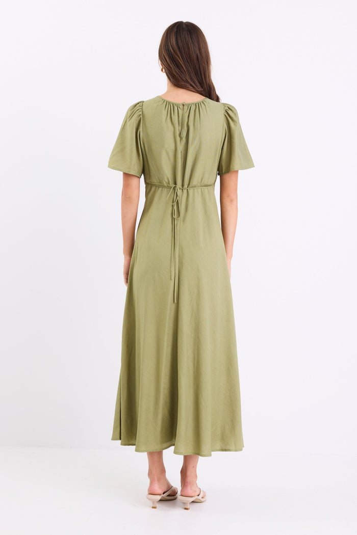 Woman wearing a long green dress with gathering and puff sleeves