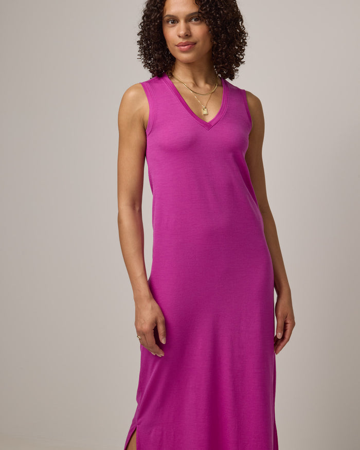 Model wearing Milena Shift Dress in Petunia, a bright fuchsia pink-purple color. Milena Shift Dress is a merino wool sleeveless, v-neck, midi shift dress available in sizes XS-3X regular, XS-XL petite.