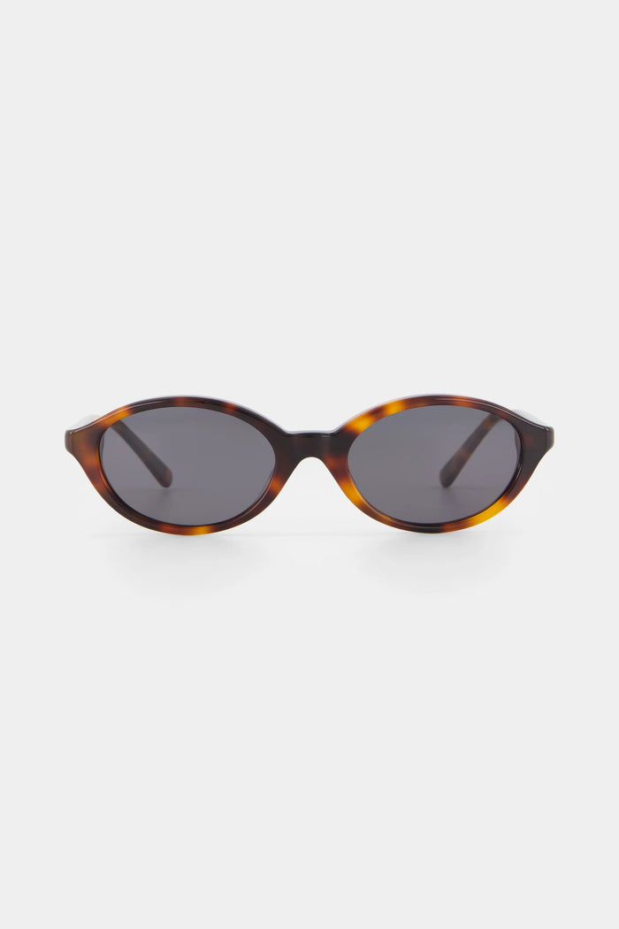 Sunglasses with tortoiseshell frame and dark lenses on a white background