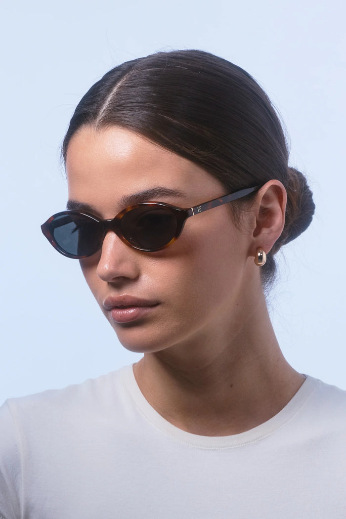 Woman wearing sunglasses with a plain background