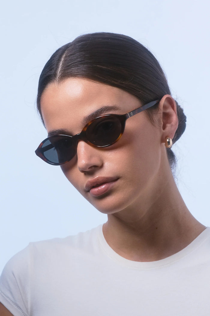Woman wearing sunglasses with a light blue background