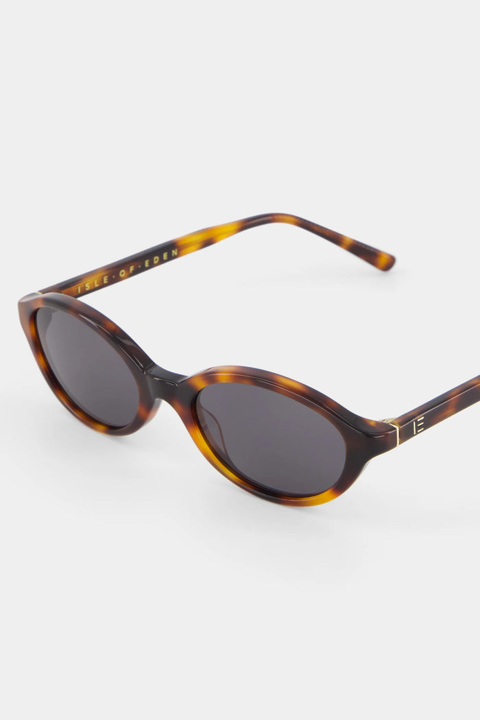 Sunglasses with tortoiseshell frame and dark lenses on a white background