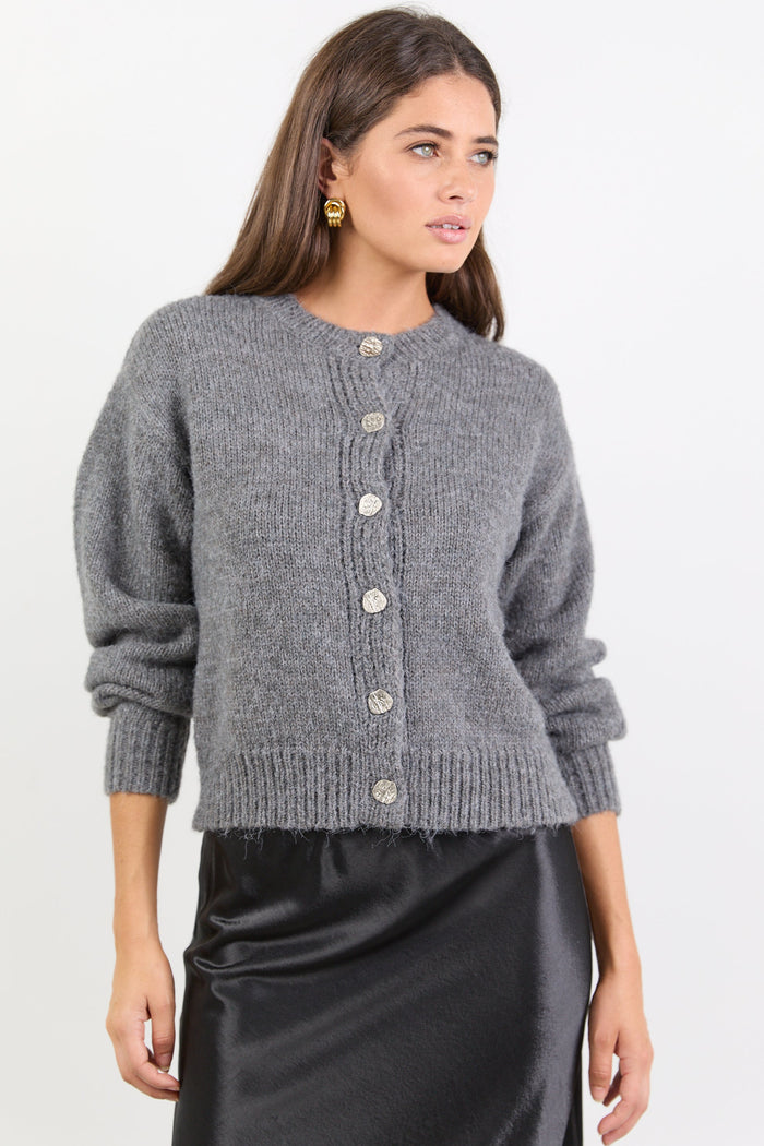 Woman wearing a grey knitted cardigan on a white background