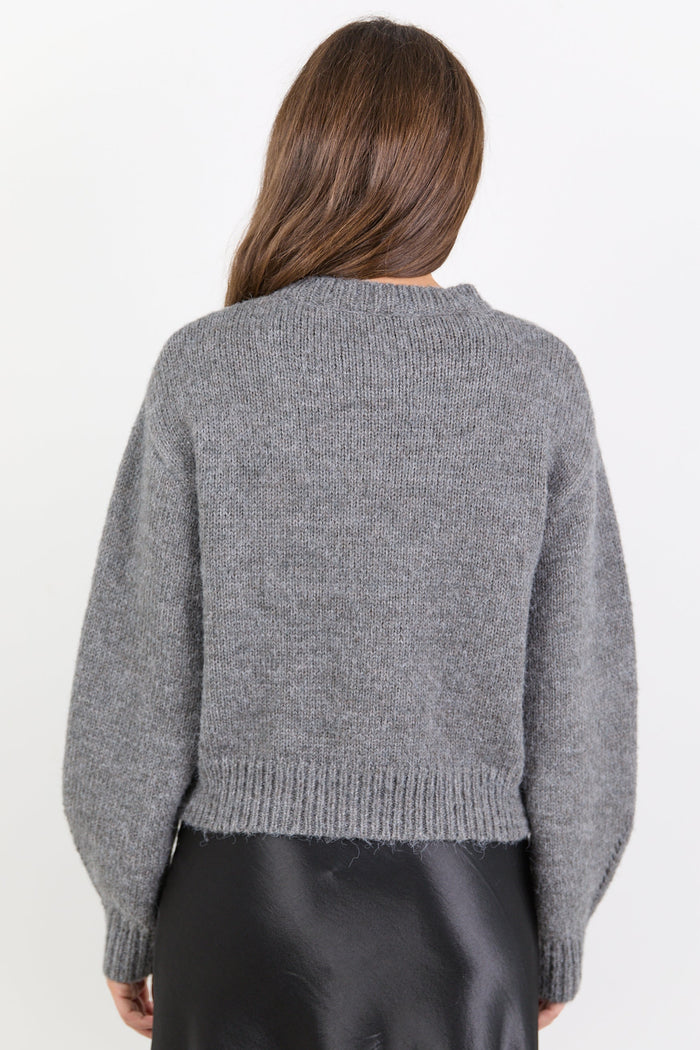 Person wearing a grey sweater on a white background
