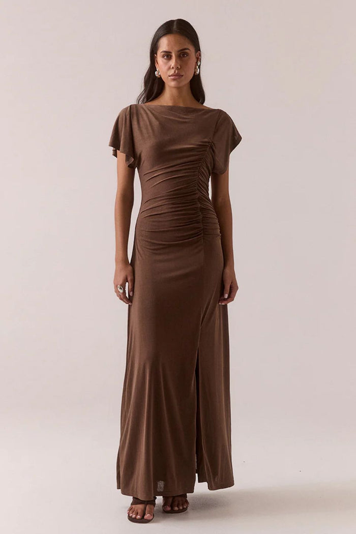 Woman wearing a brown dress with a plain background