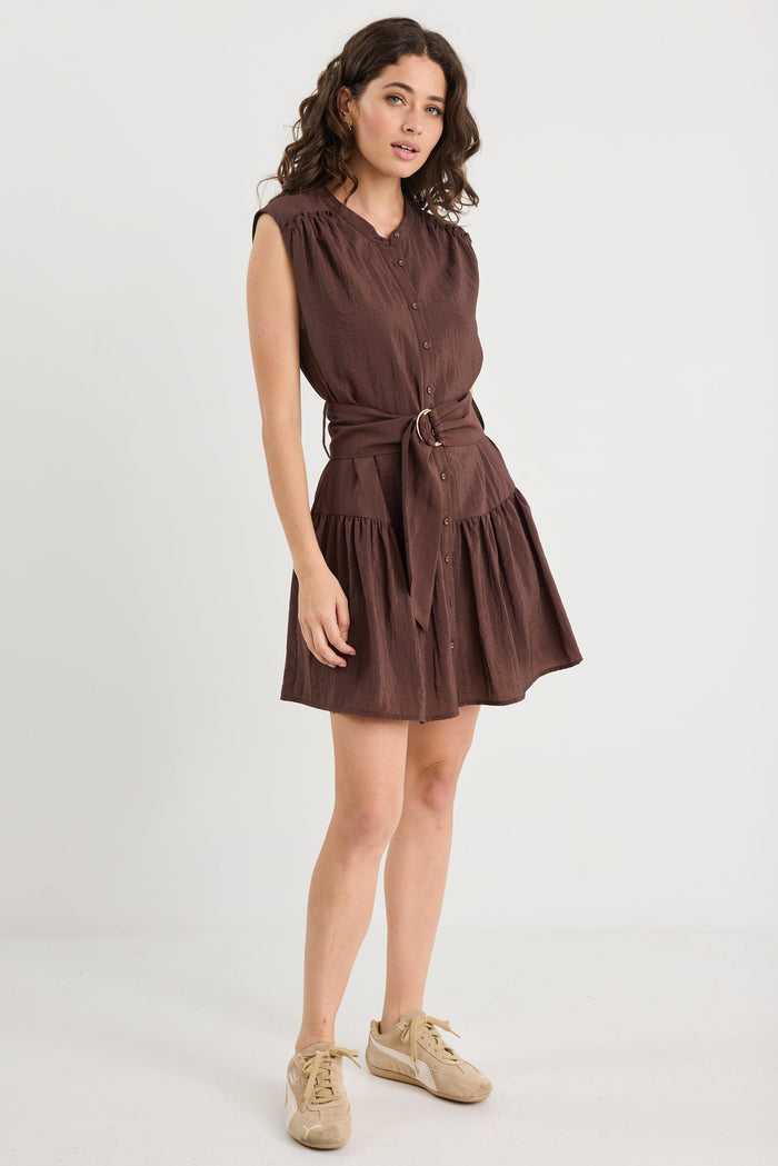 Woman wearing a brown dress with a belt on a white background