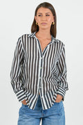Woman wearing a black and white striped shirt with blue jeans on a white background