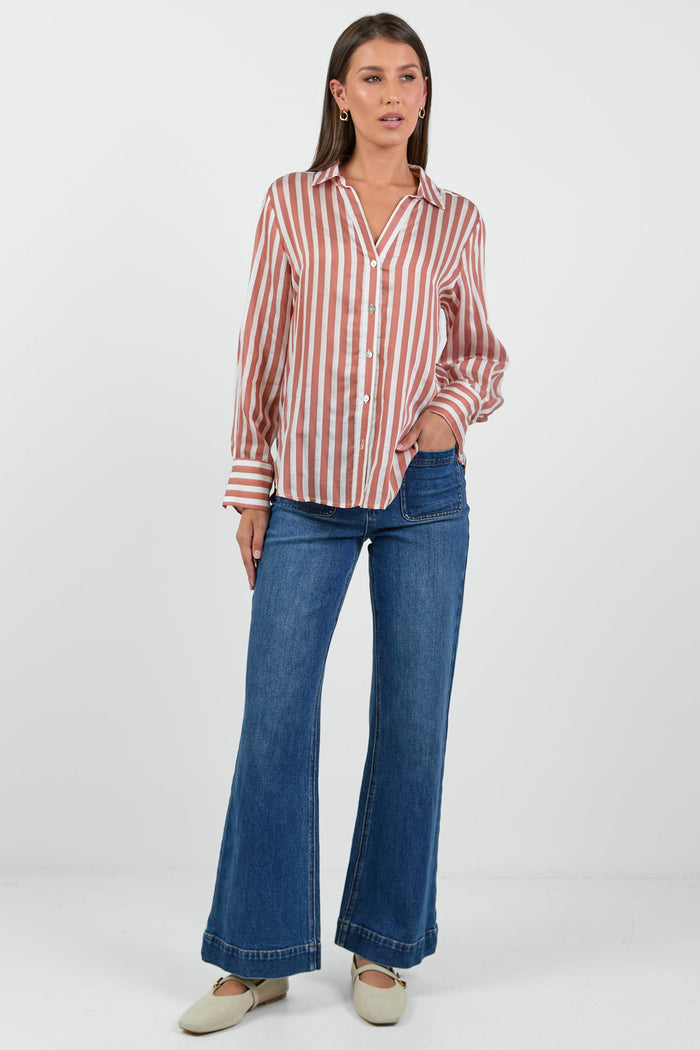 Woman wearing a striped shirt and blue jeans on a white background