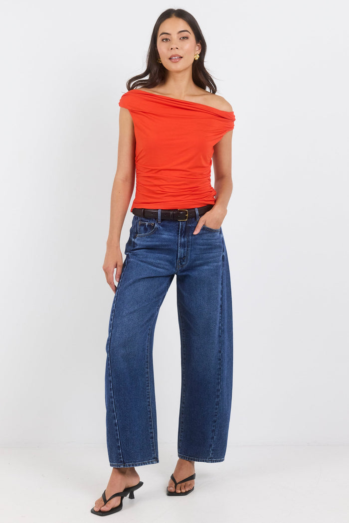 Woman wearing a red top and blue jeans on a white background
