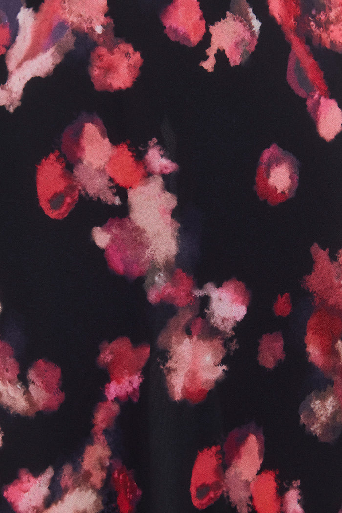 Floral patterned fabric with red, pink, and white flowers on a dark background