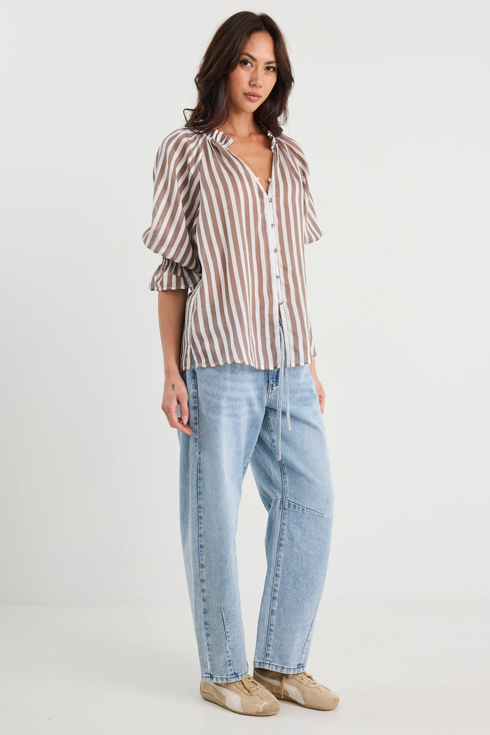 Woman wearing a striped shirt and jeans on a white background