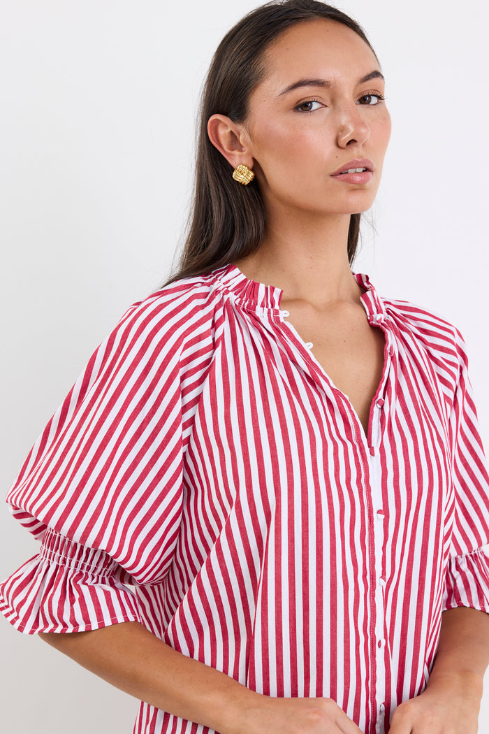 Woman wearing a red and white striped top and blue jeans