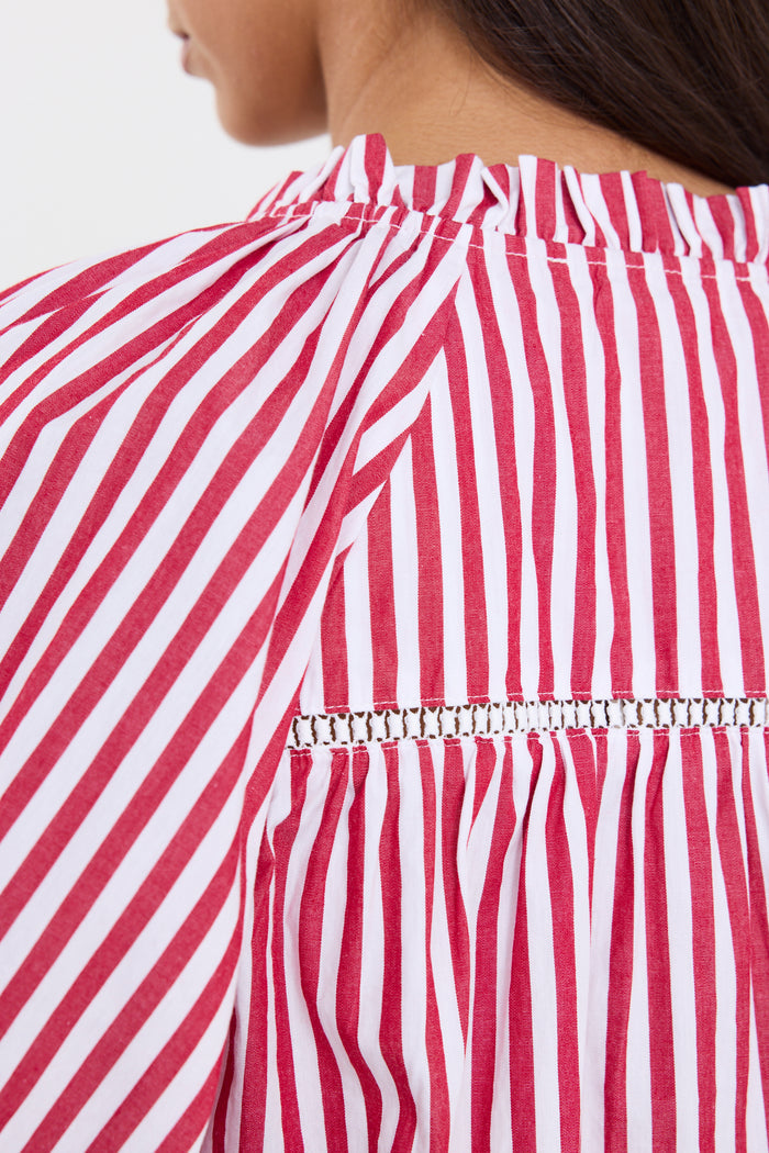 Woman wearing a red and white striped top and blue jeans