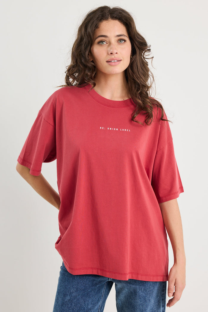 Woman wearing a red t-shirt with text on a plain background