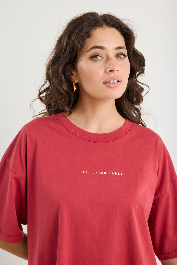 Woman wearing a red t-shirt with 'RE: UNION LABEL' text on a white background