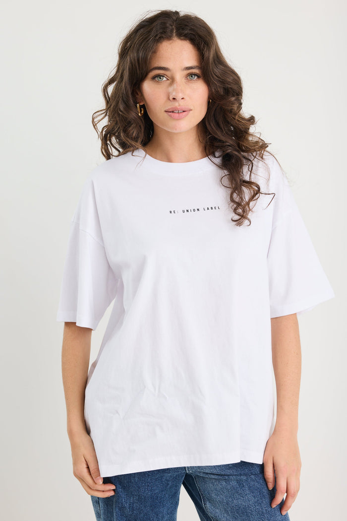 Woman wearing a white t-shirt with text on a plain background