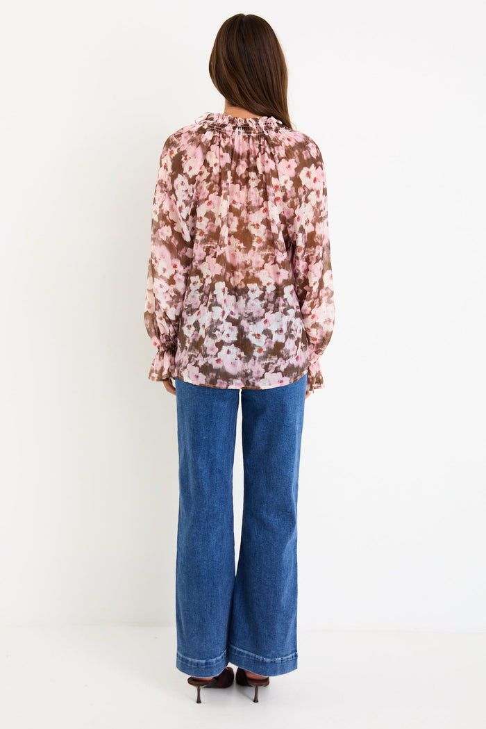 Model wearing a blush and chocolate floral long sleeve top with a shirred neckline and floaty silhouette
 @col_pattern
