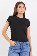 Woman wearing a black t-shirt and blue jeans against a white background