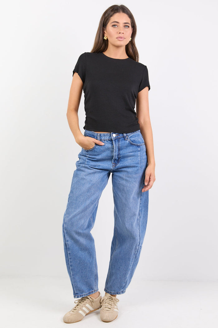 Woman wearing a black t-shirt and blue jeans on a white background