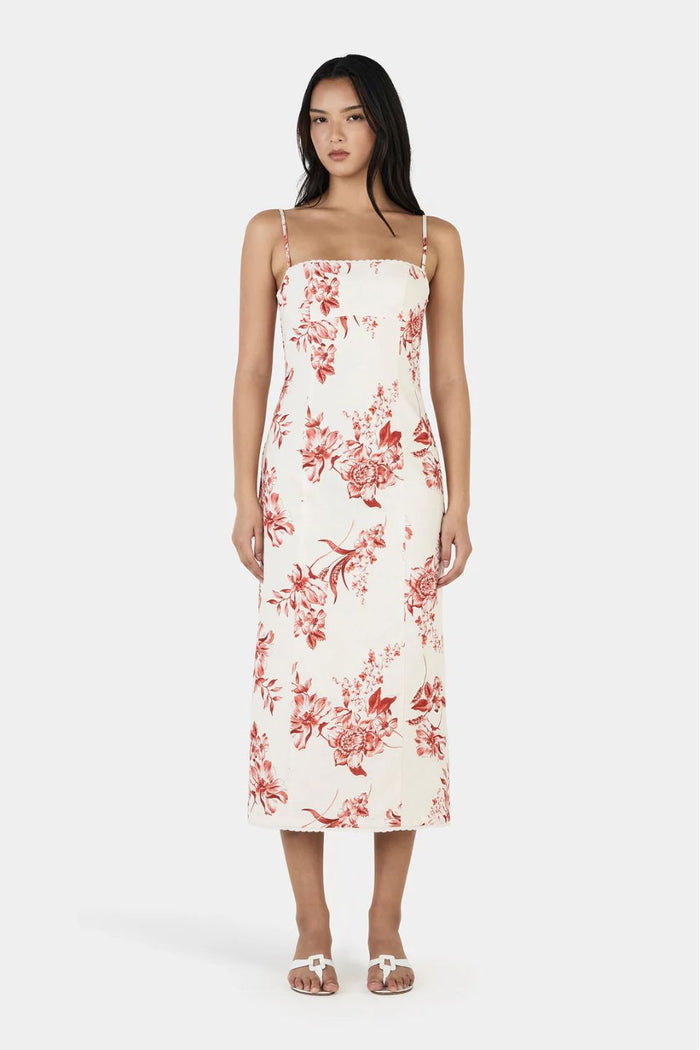 Woman wearing a white dress with red floral pattern on a white background