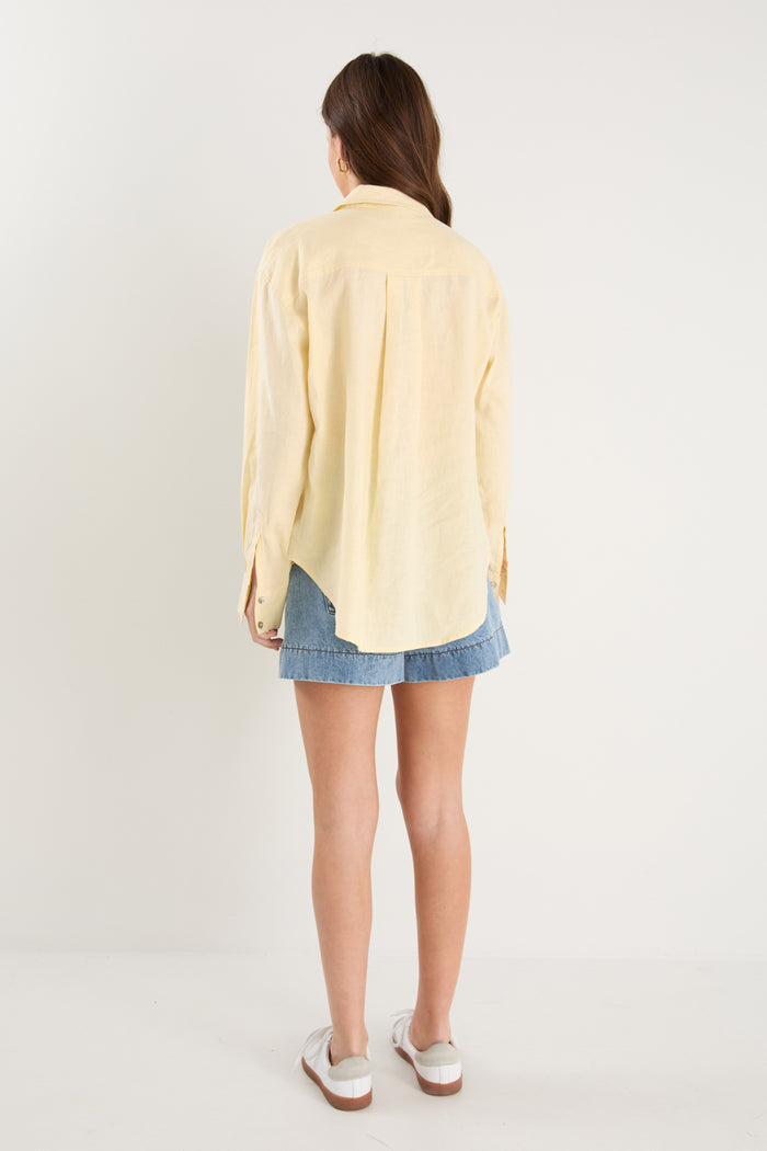 Model wears a yellow linen shirt with denim shorts and white sneakers
@col_pattern