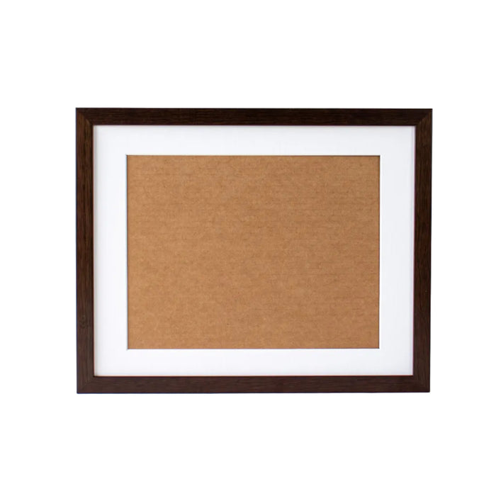 Brown cork bulletin board in a dark wooden frame on a white background