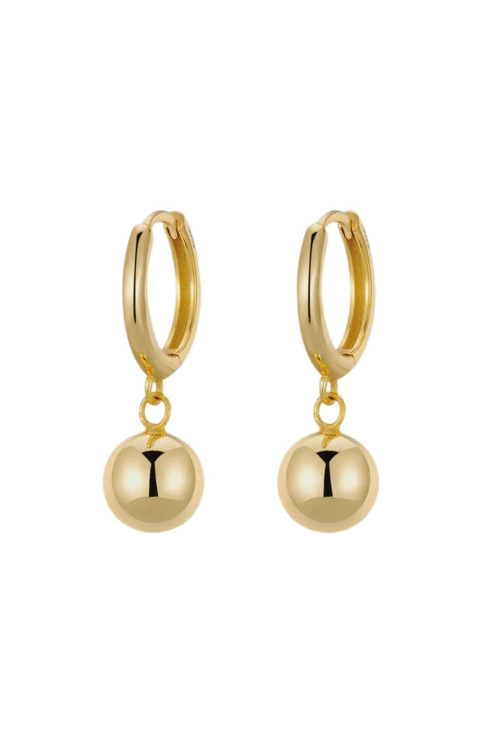 Gold hoop earrings with round dangling beads on a white background