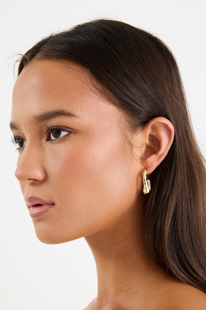 woman wearing a gold earring
