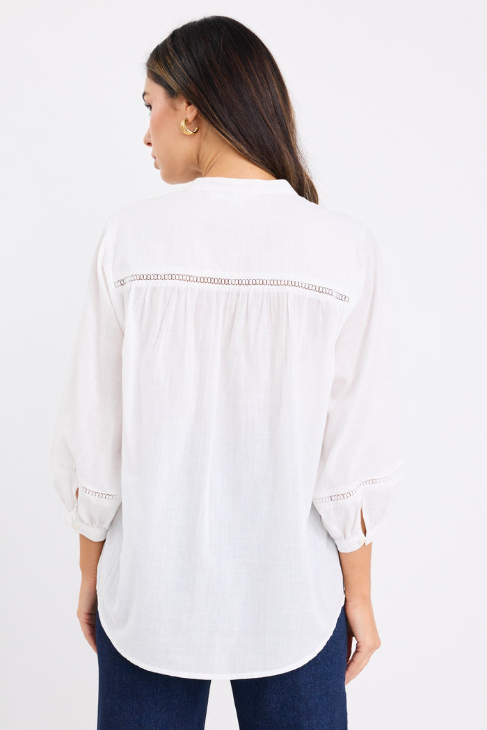 women wears a white blouse with dark blue jeans
col_pattern
