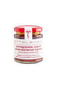 A glass jar of Ottolenghi pomegranate, rose & preserved lemon harissa paste with a red lid and white label, centered on a plain white background.