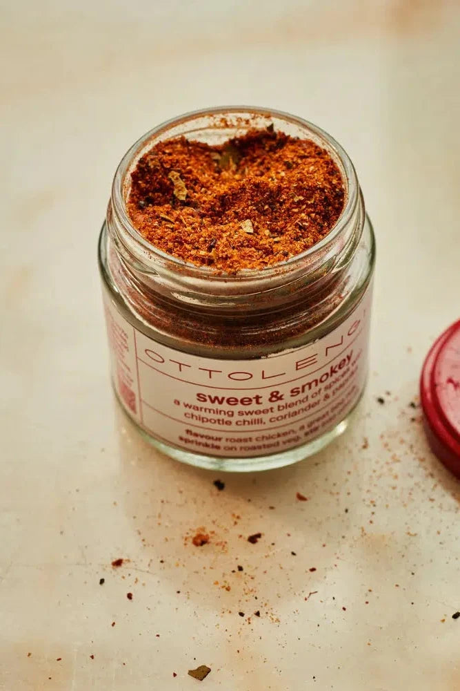 Jar of sweet and smoky seasoning with a red lid on a beige surface