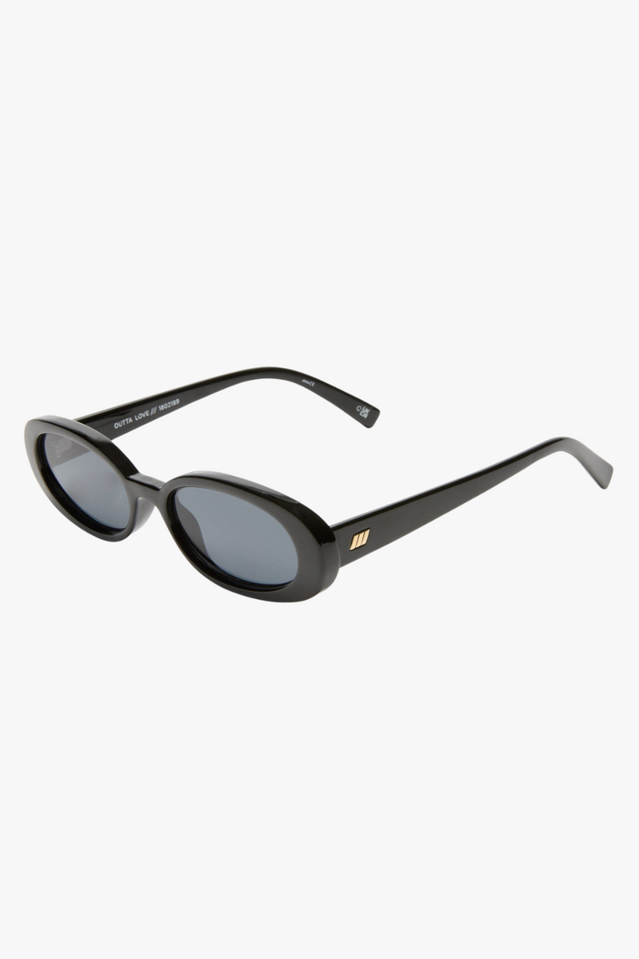 Front-facing view of slim oval sunglasses in a glossy black frame with smoke-tinted lenses. The sleek, narrow silhouette channels a strong 90s influence, offering a bold, minimalist look.