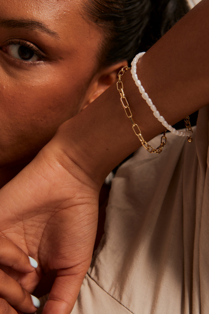 Model wears a gold chain bracelet