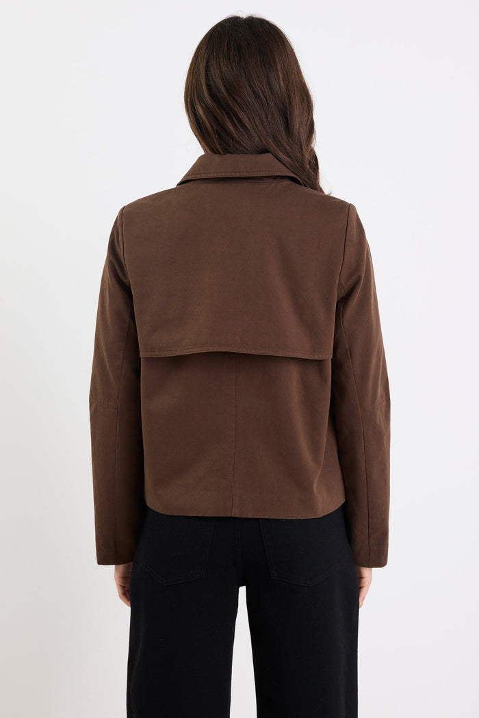 Person wearing a brown jacket on a white background
col_pattern