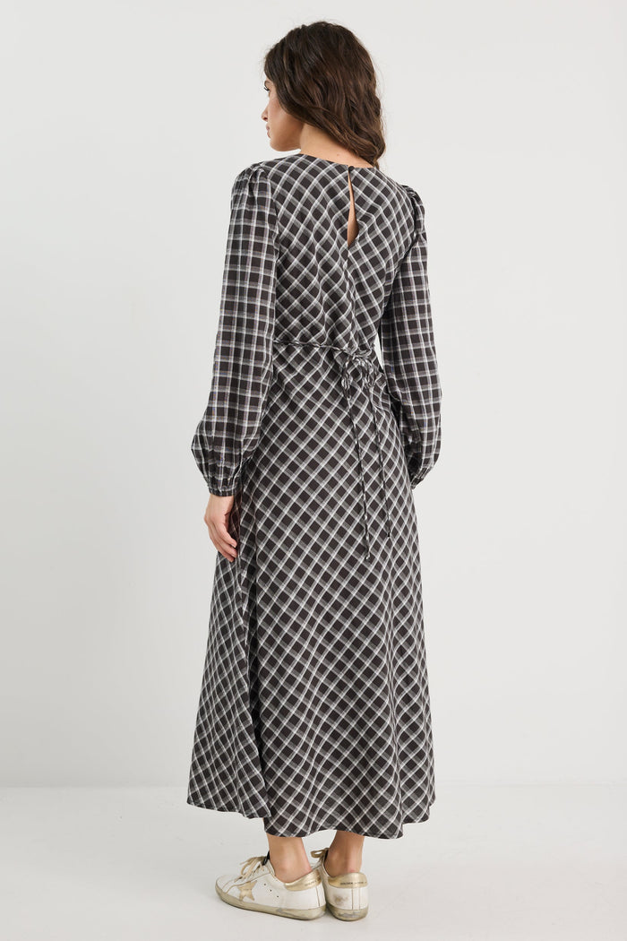 Woman wearing a long black and white checkered dress on a white background