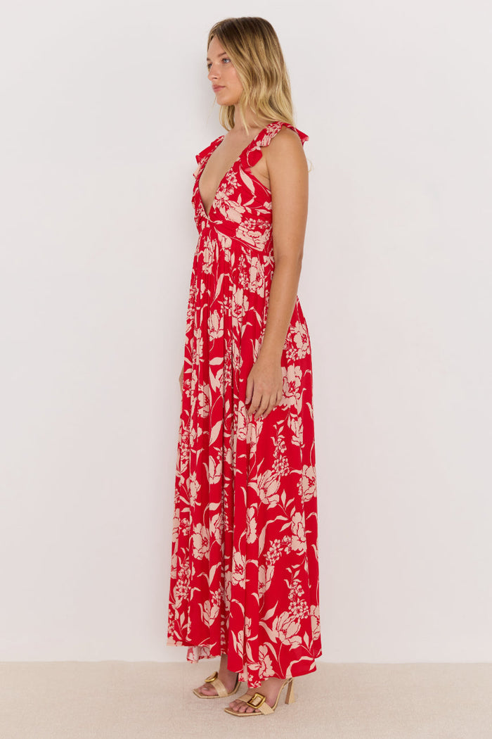 Woman wearing a red floral dress against a white background