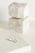 A pair of gold-toned stud earrings shaped like small flowers, featuring a pearlescent centre framed by a polished gold outline for a soft, elegant finish