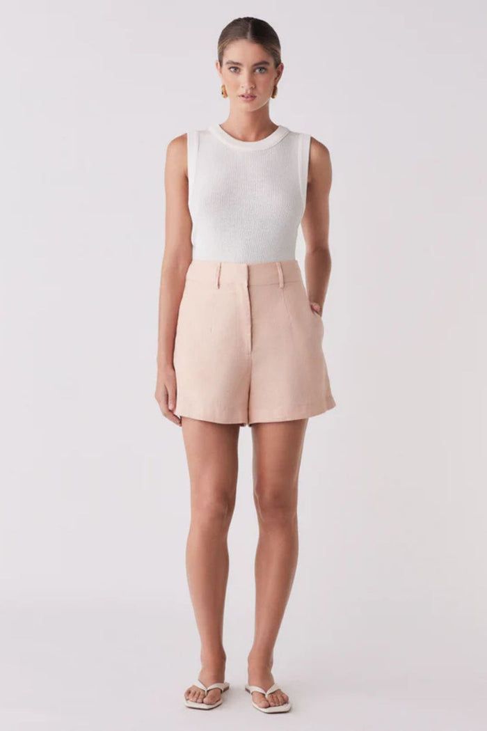 Woman wearing a pink short and white tank top
