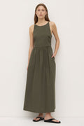 A woman wearing a sleeveless khaki green midi dress with a high neckline, fitted bodice, and gathered waist. The dress has side pockets and a relaxed A-line silhouette, styled simply with black sandals.’