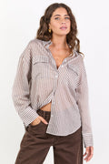 Woman wearing a striped shirt and brown pants on a white background