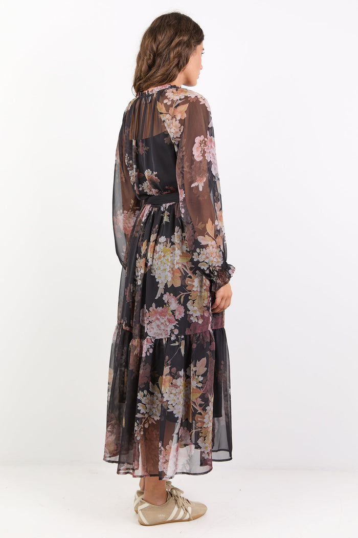 Woman wearing a floral dress with long sleeves on a white background