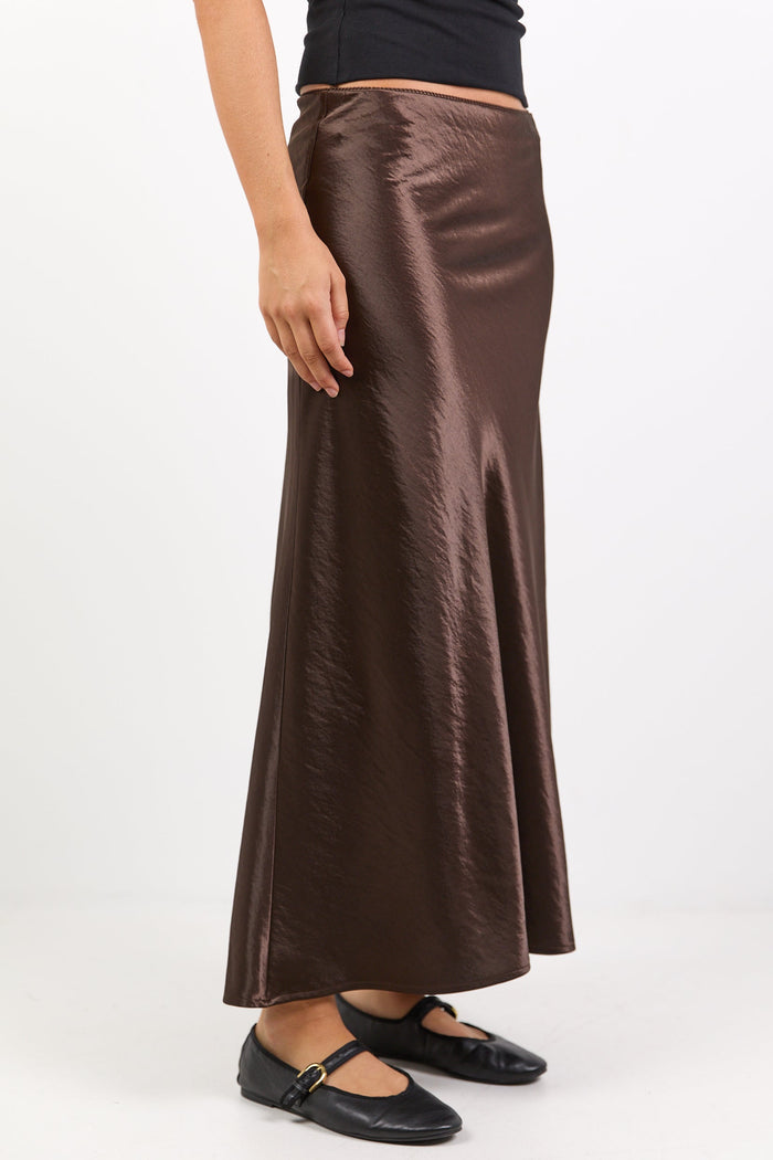 Person wearing a brown satin skirt on a white background