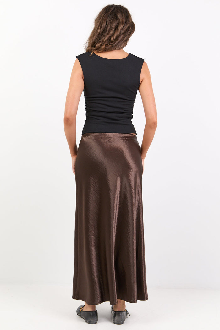 Woman wearing a black top and brown skirt on a white background