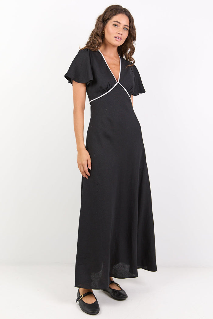 Woman wearing a black dress with ruffled sleeves on a white background