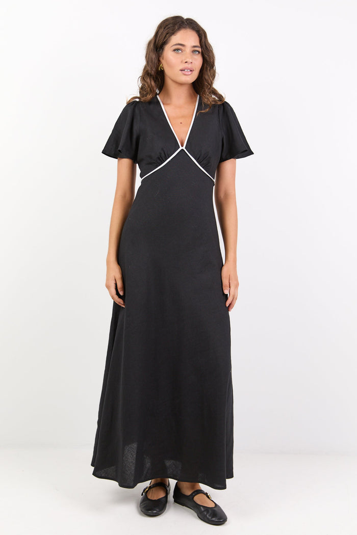Woman wearing a black dress with white trim on a white background