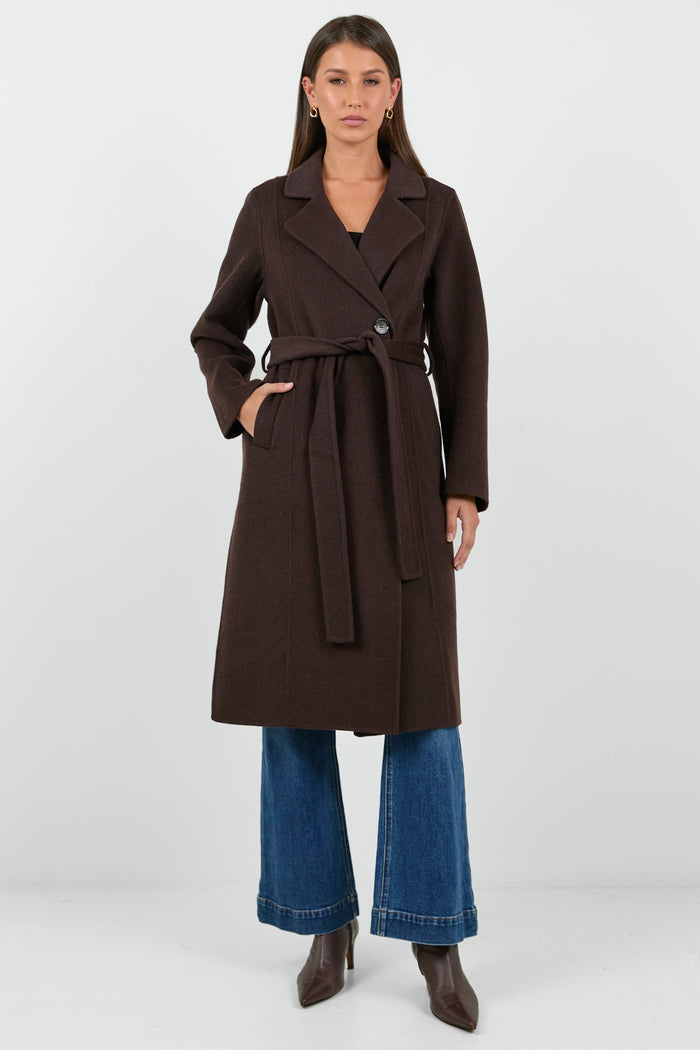 Woman wearing a brown coat with a white background