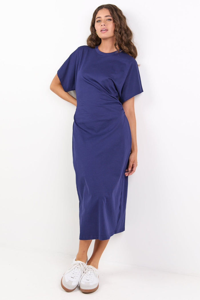 Woman wearing a blue dress standing against a white background