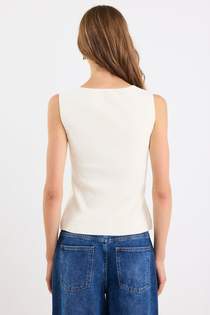 Person wearing a white sleeveless top and blue jeans on a white background
col_pattern